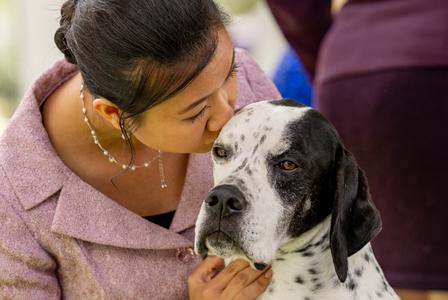 woman kissing dog on head