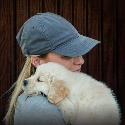 Pet Expert Team, woman in blue ball cap holding puppy